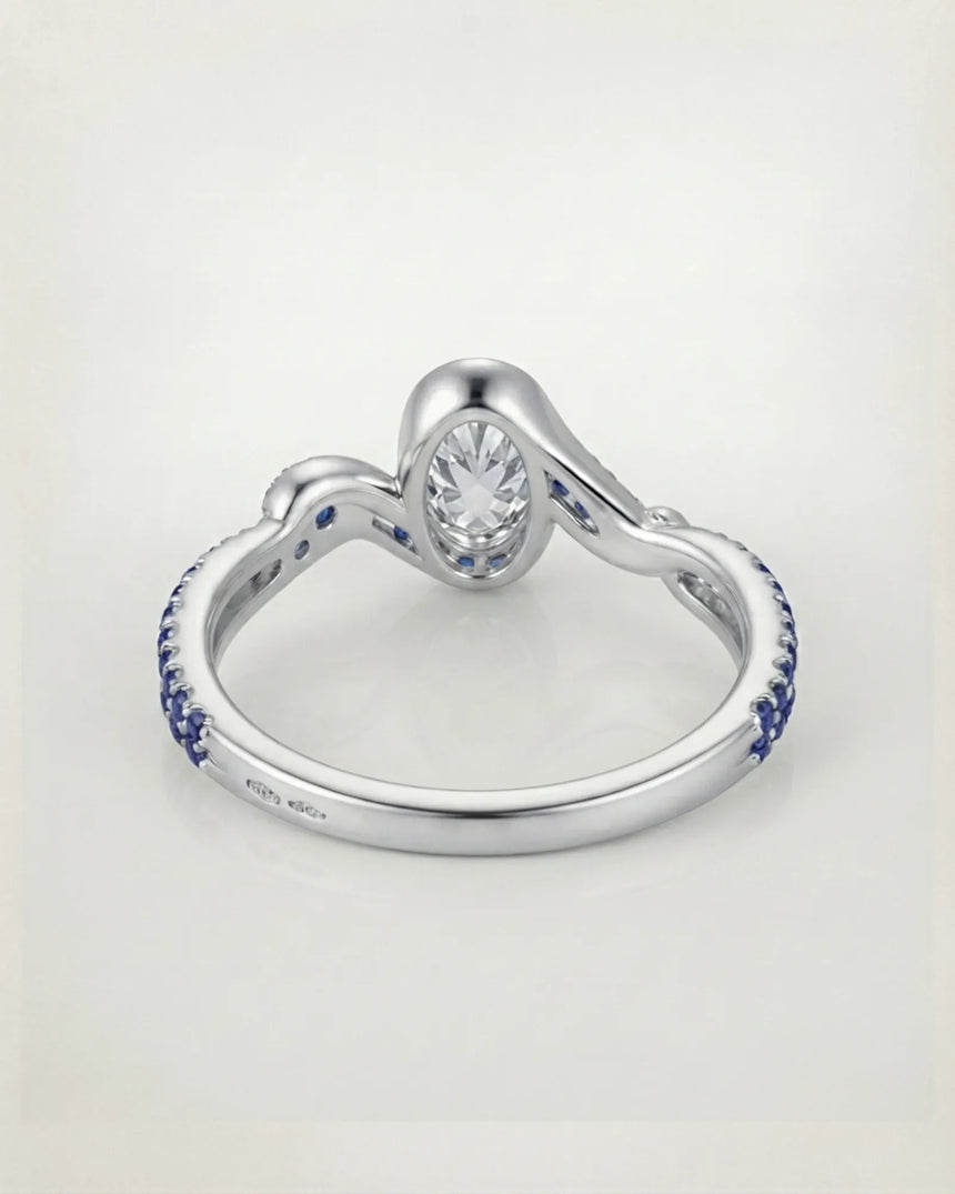 Luxury oval moissanite and natural sapphire ring with sculptural white gold ribbon setting | SARATTI
