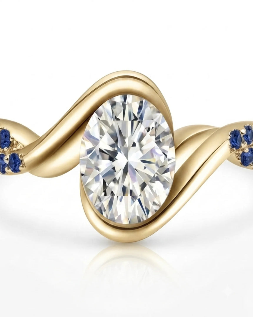 Luxury oval moissanite and natural sapphire ring with sculptural yellow gold ribbon setting | SARATTI.