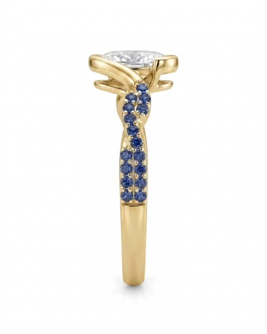 Luxury oval moissanite and natural sapphire ring with sculptural yellow gold ribbon setting | SARATTI