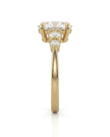 Luxury oval moissanite ring with graduated side stones and rich yellow gold setting | SARATTI