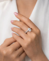 Luxury pear cut moissanite ring with sculptural gallery and brilliant shoulder accents in 18K white gold | SARATTI