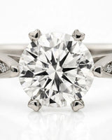 Luxury round moissanite ring with pavé shoulders and elevated six-prong profile | SARATTI