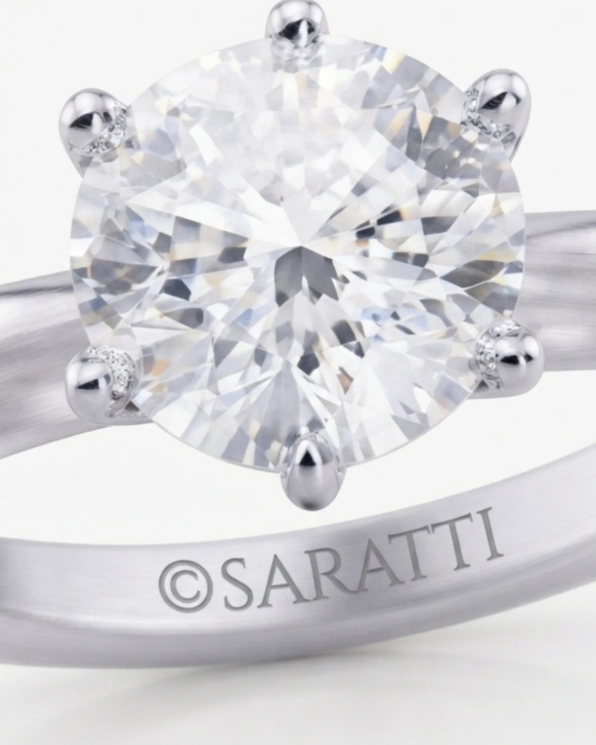 Luxury round moissanite solitaire in 18K white gold with refined architectural setting | SARATTI.
