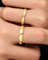 Matching wedding band set with flowing X-inspired structure and smooth 18K yellow gold finish | SARATTI
