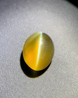 Natural 2.00 carat Honey Color Cat's Eye Chrysoberyl oval cabochon under directional light | SARATTI