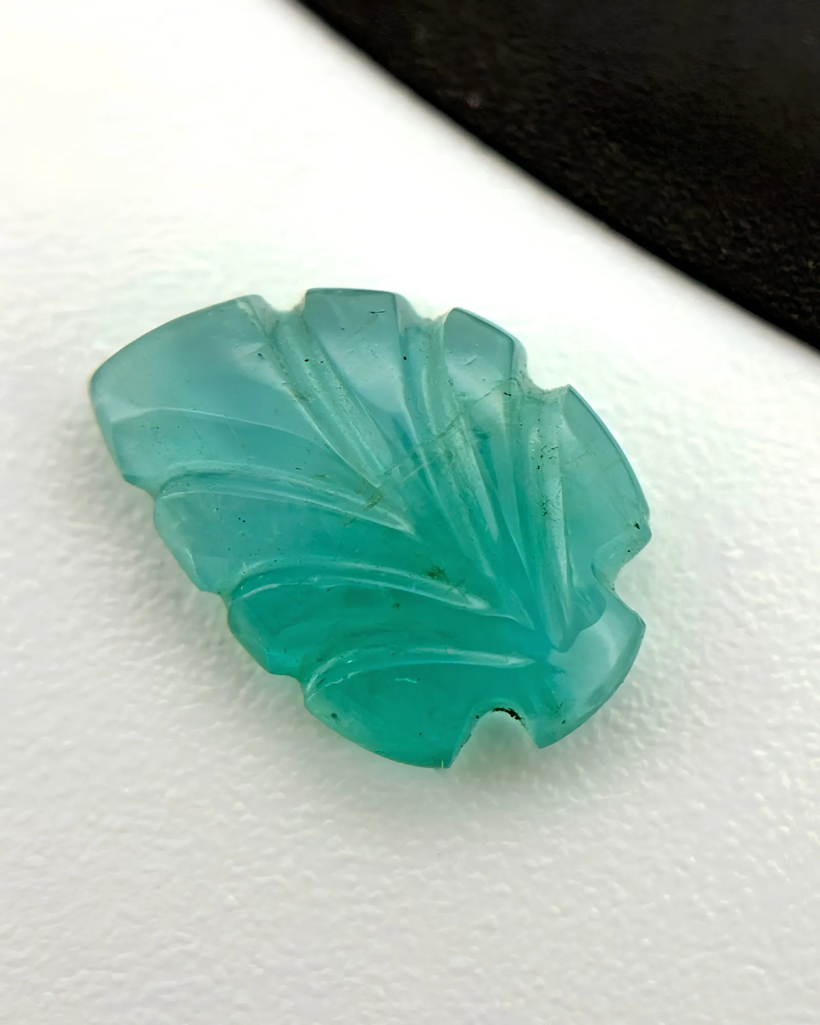 Natural Emerald carved leaf loose gemstone shown from an alternate angle | SARATTI