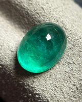 Natural Emerald oval cabochon loose gemstone shown at an alternate angle | SARATTI