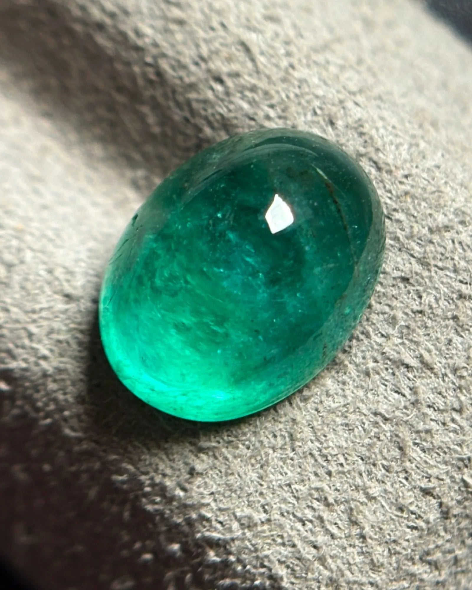 Natural Emerald oval cabochon loose gemstone shown at an alternate angle | SARATTI