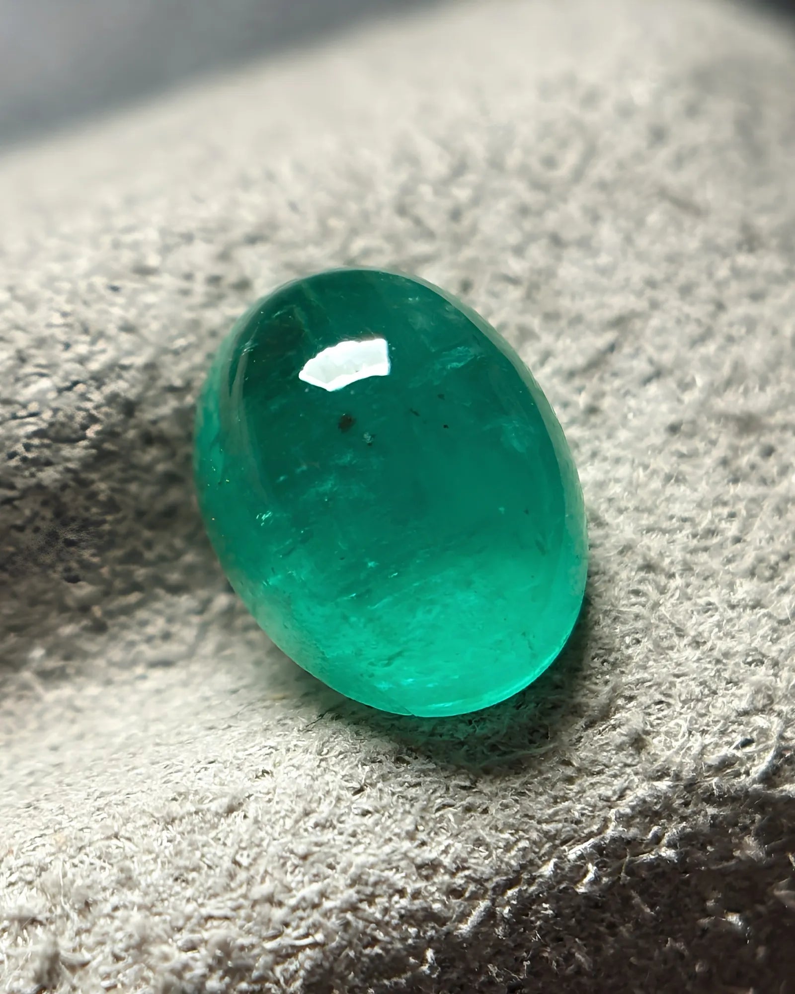 Natural Emerald oval cabochon loose gemstone shown from an alternate angle | SARATTI
