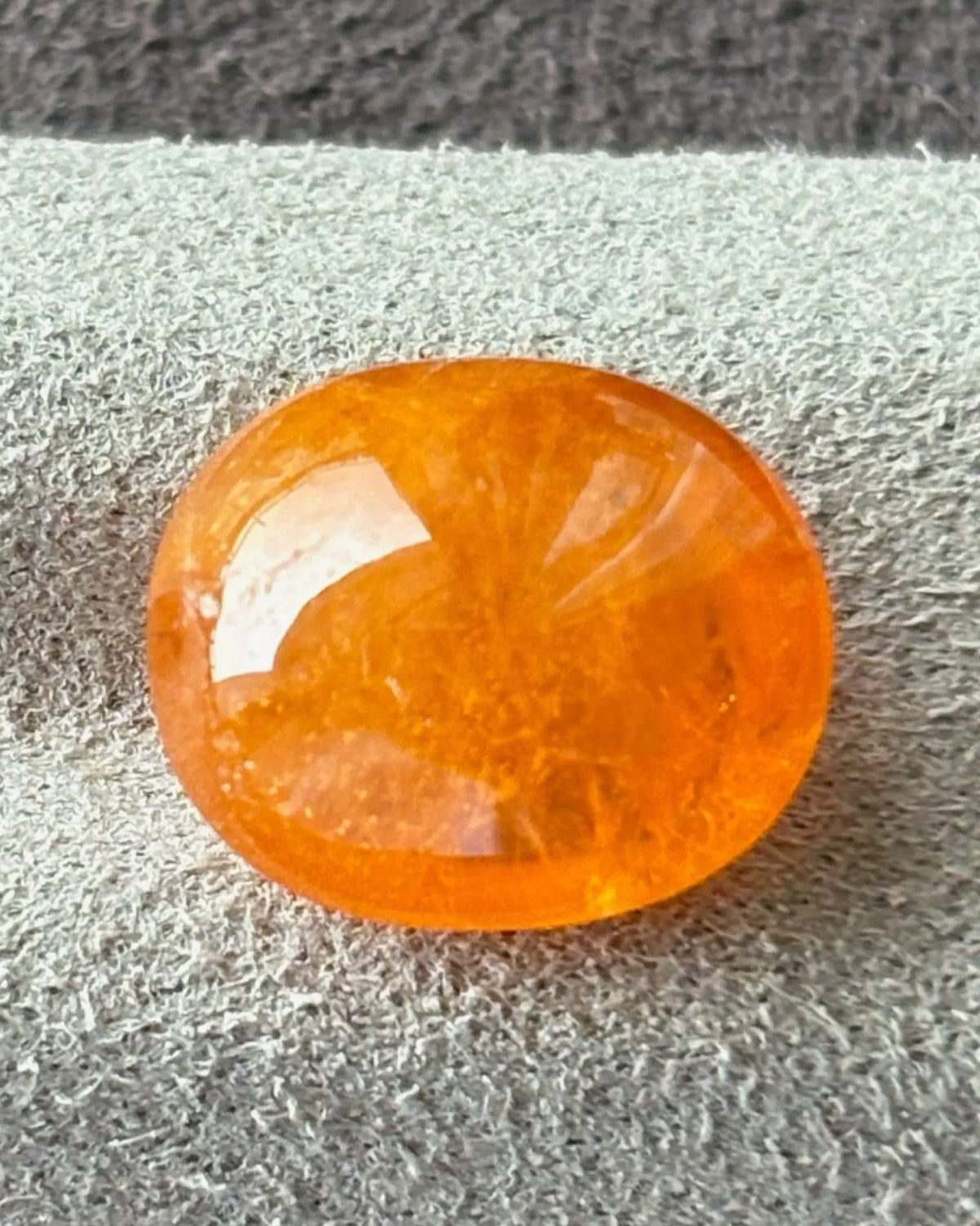 Natural Fanta Orange Spessartine Garnet oval cabochon on white | SARATTI