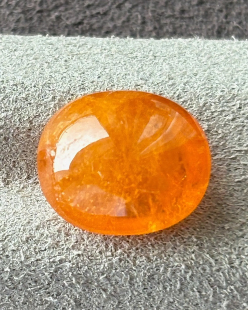 Natural Fanta Orange Spessartine Garnet oval cabochon on white | SARATTI