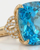Natural cushion Swiss Blue topaz ring framed by sculpted diamond details in 18K yellow gold | SARATTI