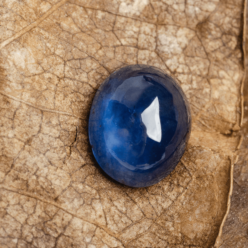 Natural oval blue sapphire gemstone showing polished cabochon surface | SARA