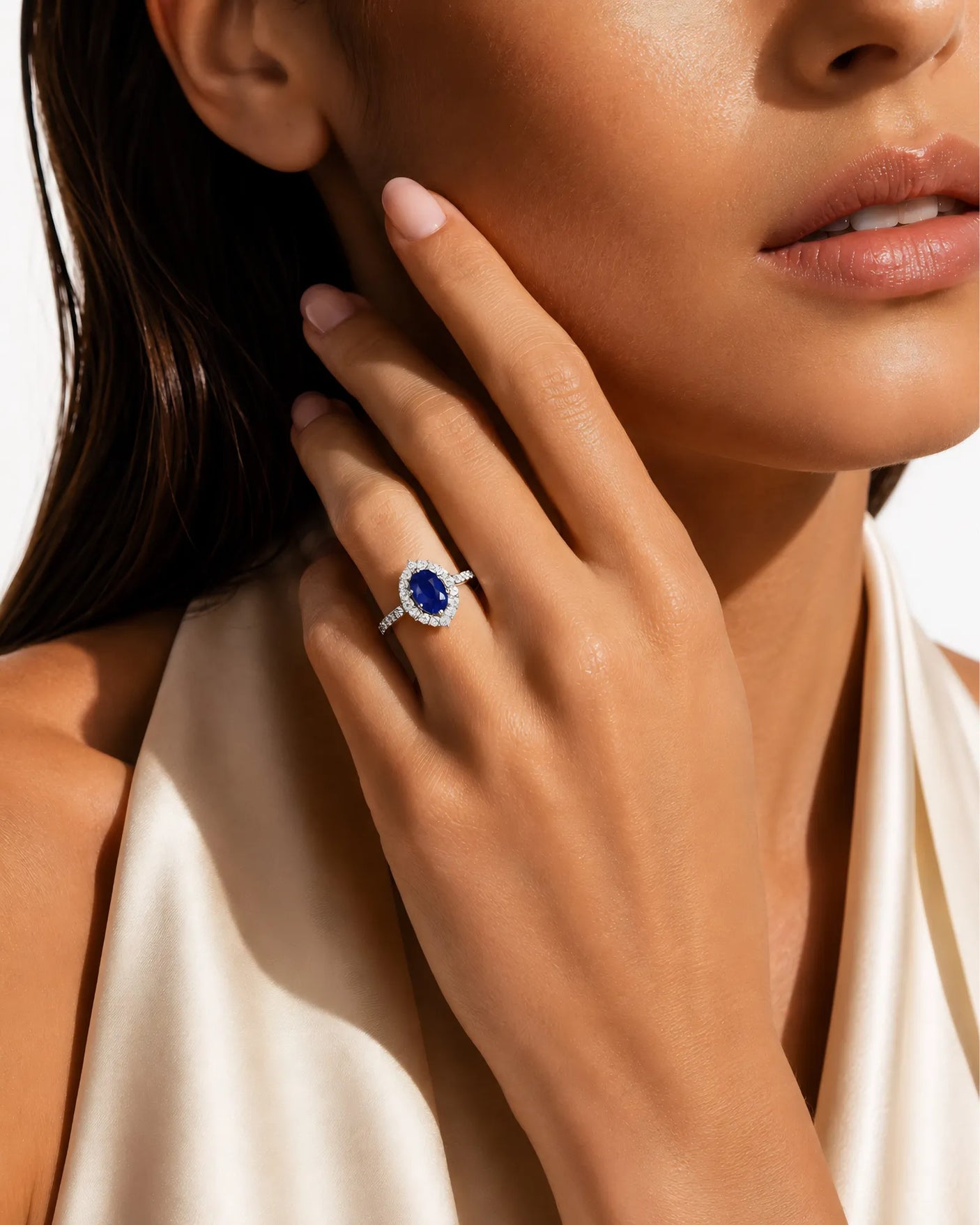 Natural oval blue sapphire ring framed by round diamonds in platinum | SARATTI