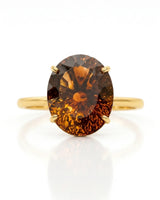 Oval Imperial Topaz solitaire ring with open floral basket and warm 18K yellow gold band | SARATTI
