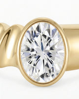 Oval bezel moissanite engagement ring for a minimalist modern proposal in 18K yellow gold | SARATTI
