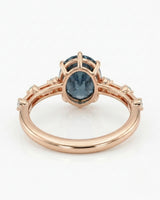 Oval blue moissanite center with colorless round side stones in 18K rose gold | SARATTI