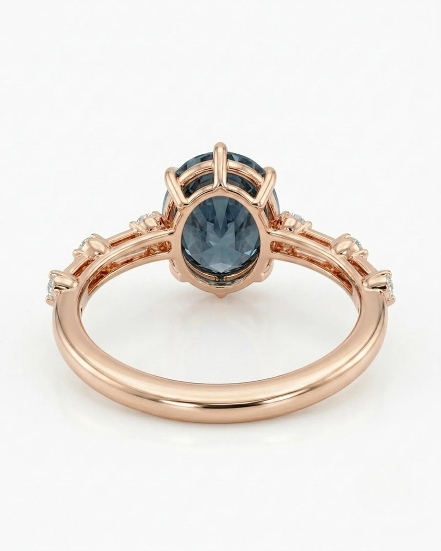 Oval blue moissanite center with colorless round side stones in 18K rose gold | SARATTI