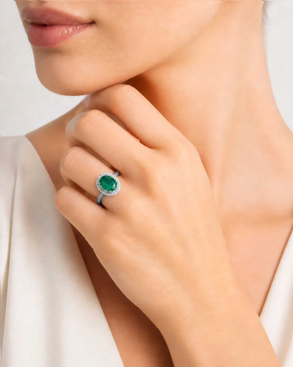 Oval cut natural emerald halo ring with diamond accents in white gold | SARATTI