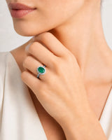 Oval cut natural emerald halo ring with diamond accents in white gold | SARATTI