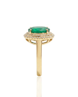 Oval cut natural emerald halo ring with diamond accents in yellow gold | SARATTI