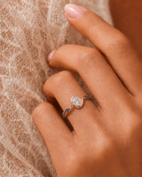 Oval moissanite bezel ring in rose gold with twisted sapphire-set shoulders and open gallery | SARATTI