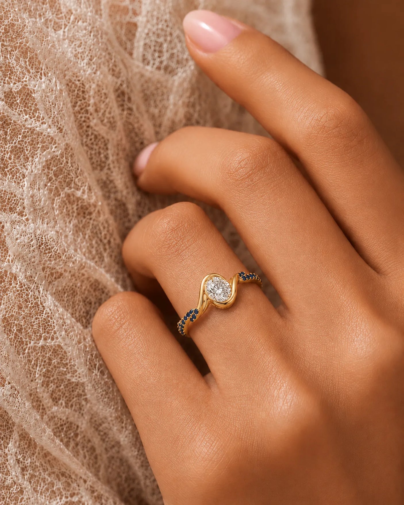 Oval moissanite bezel ring in yellow gold with twisted sapphire-set shoulders and open gallery | SARATTI