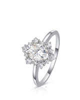 Oval moissanite engagement ring with floral halo and round accents in 18K white gold | SARATTI