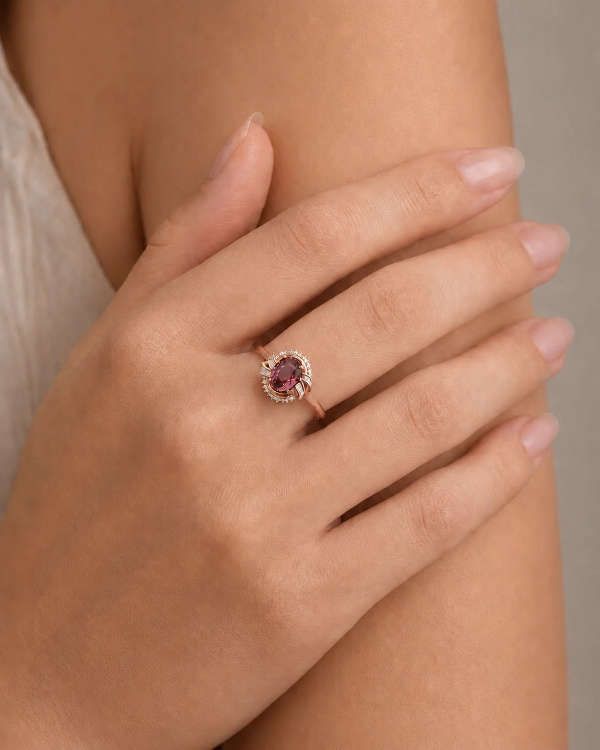 Oval pink tourmaline ring with baguette diamond shoulders and round halo accents in 18K rose gold | SARATTI