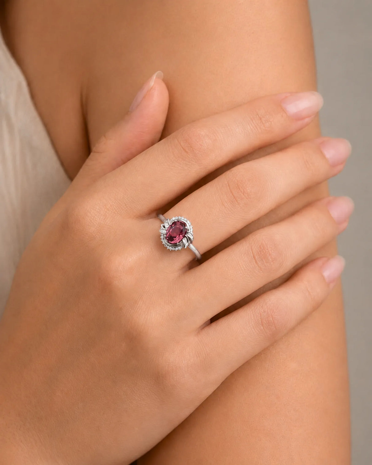 Oval pink tourmaline ring with baguette diamond shoulders and round halo accents in 18K white gold | SARATTI