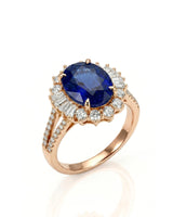 Oval royal blue sapphire ring with diamond halo and split shank in 18K rose gold | SARATTI