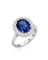 Oval royal blue sapphire ring with round diamond floral halo in 18K white gold | SARATTI