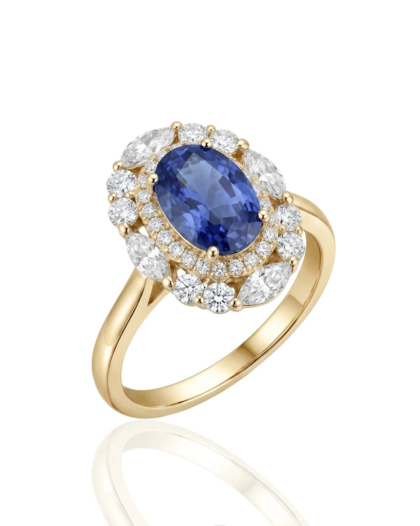 Oval royal blue sapphire ring with round diamond halo in 18K yellow gold | SARATTI