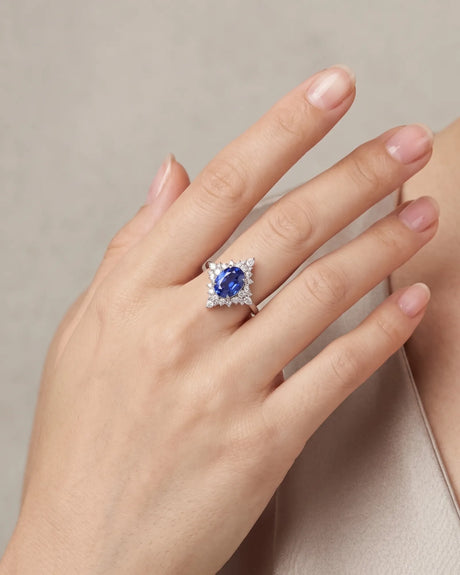 Oval sapphire ring with elongated diamond halo and sculptural 900 platinum setting for statement elegance | SARATTI