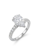 Pear cut moissanite engagement ring with scallop-set round side stones in polished platinum | SARATTI