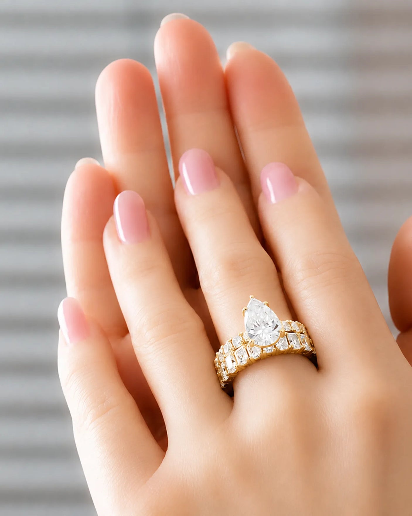 Pear cut moissanite ring in yellow gold with brilliant shoulder accents and elegant profile | SARATTI