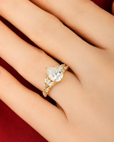 Pear moissanite engagement ring in yellow gold with marquise leaf accents and refined elegance | SARATTI