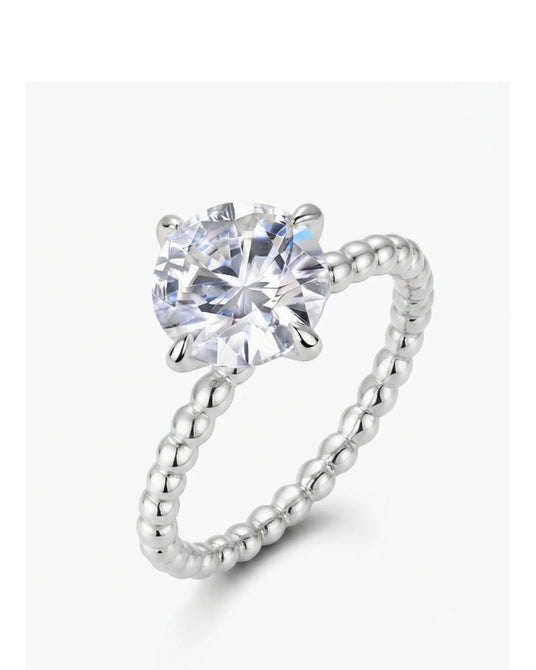 Platinum round moissanite engagement ring with polished beaded band and four-prong solitaire setting | SARATTI
