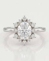 Romantic floral moissanite ring with oval center and crown-like halo in polished platinum | SARATTI