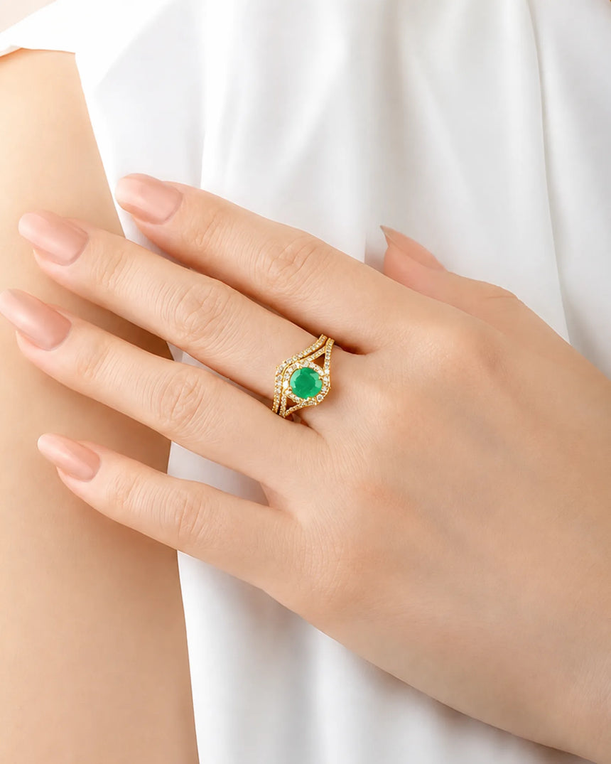 Round emerald bridal set in yellow gold with colorless moissanite accents and open shoulders | SARATTI