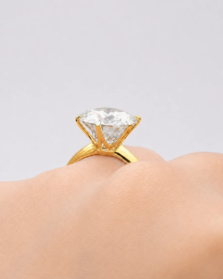 Round moissanite ring in yellow gold with elevated crown and minimalist solitaire profile | SARATTI