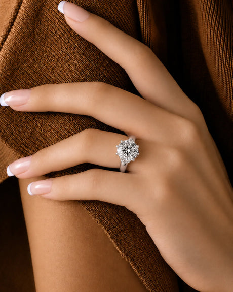 Round moissanite solitaire in white gold with sculptural prongs and polished plain band | SARATTI