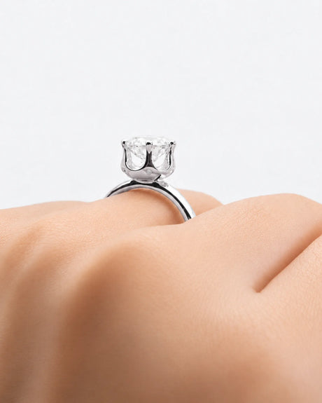 Round moissanite solitaire ring in 18K white gold with tulip-inspired crown and polished band | SARATTI