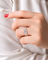 Round moissanite trilogy design framed by graduated side stones in warm 18K rose gold | SARATTI