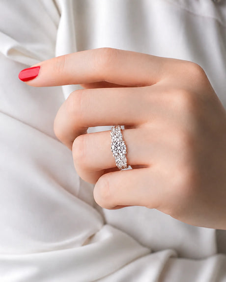 Round moissanite trilogy ring with graduated side stones and split-shank pavé in white gold | SARATTI