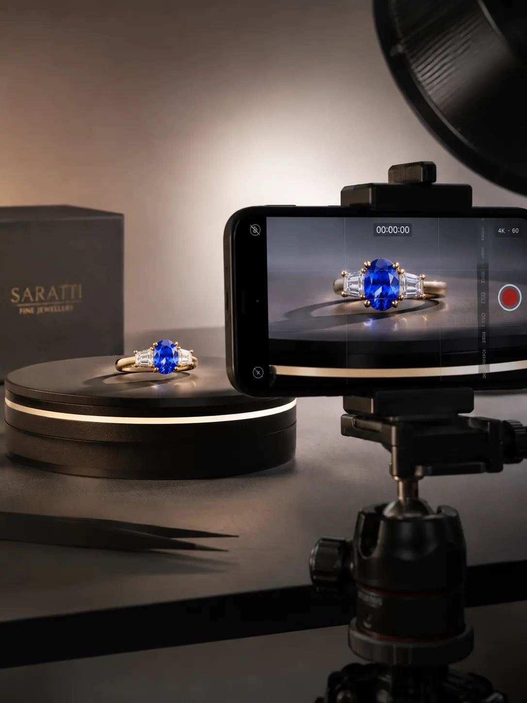 Behind-the-scenes SARATTI 4K film setup showing a sapphire and diamond ring on a rotating display captured for client review