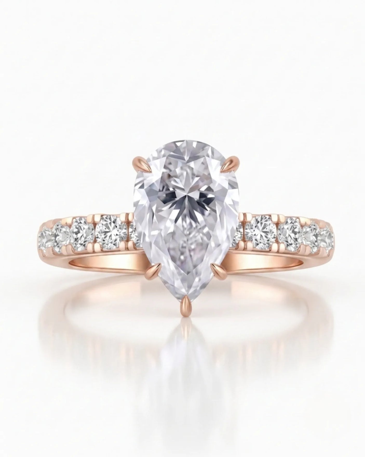 Sculptural pear moissanite ring with hidden halo and accented shoulders in polished 18K rose gold | SARATTI