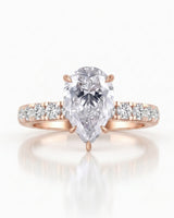 Sculptural pear moissanite ring with hidden halo and accented shoulders in polished 18K rose gold | SARATTI
