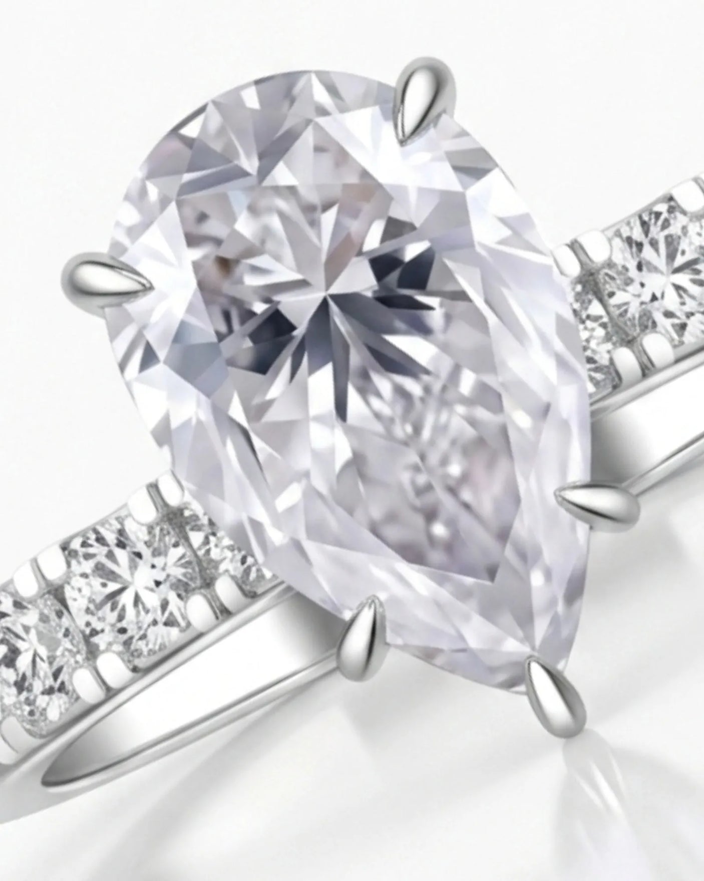 Sculptural pear moissanite ring with hidden halo and accented shoulders in polished 18K white gold - SARATTI