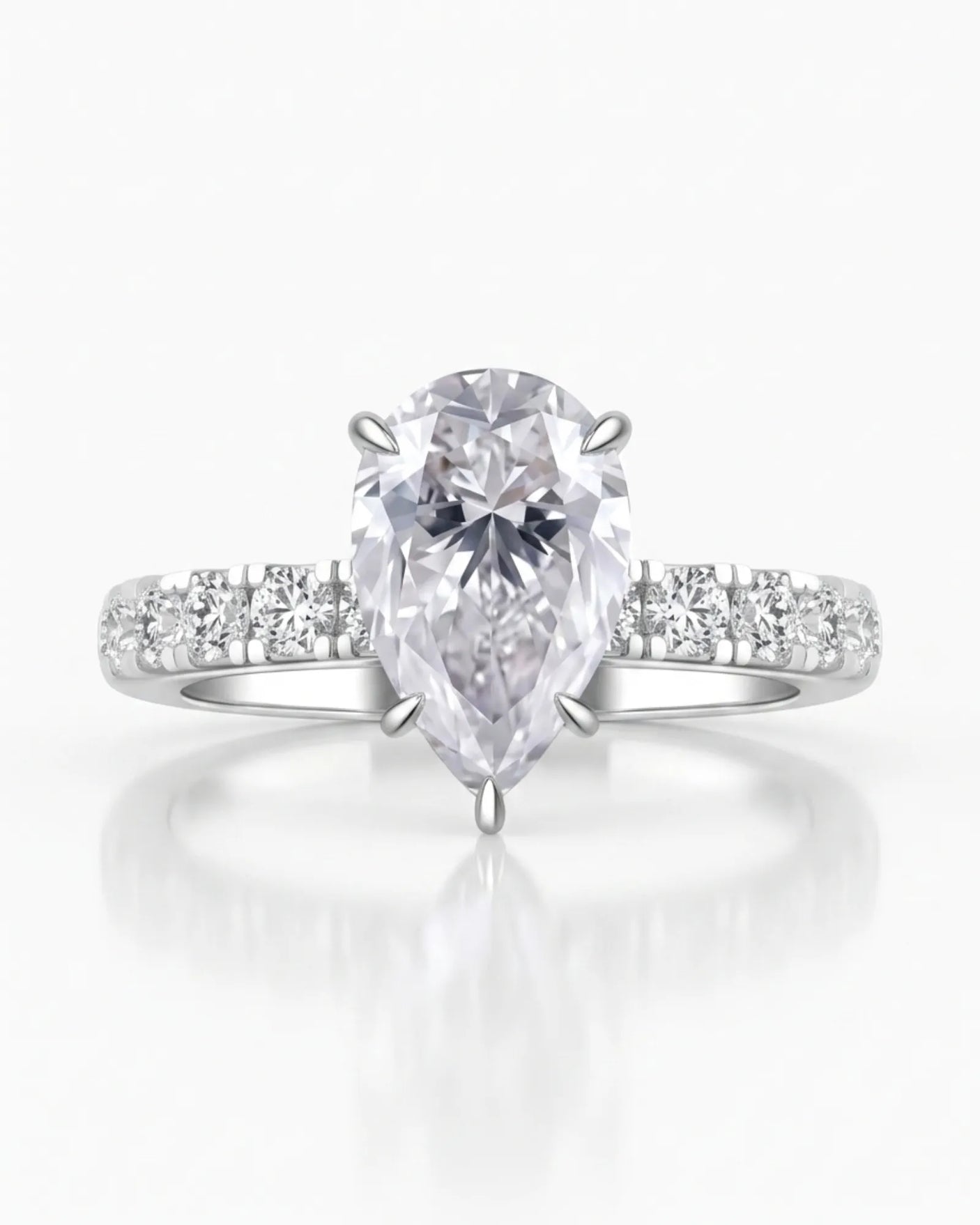 Sculptural pear moissanite ring with hidden halo and accented shoulders in polished 18K white gold | SARATTI